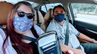 Traveling with sarcoidosis | Sarcoidosis News | Kerry and husband in a car, both wearing face masks. Kerry is holding up travel documents.