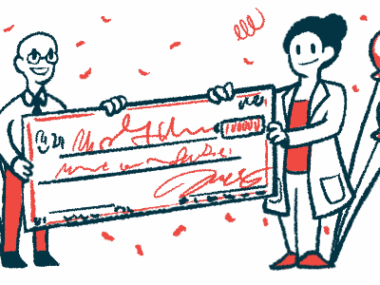 Two people each hold a side of a giant check amid confetti and balloons.