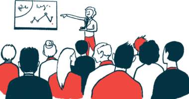 A person points to a chart on a wall in front of a conference audience.
